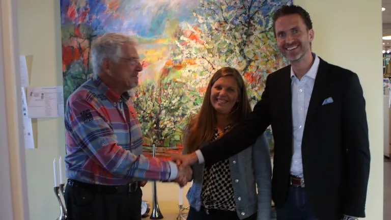 Handshake between three people at the acquisition of Time Terminal