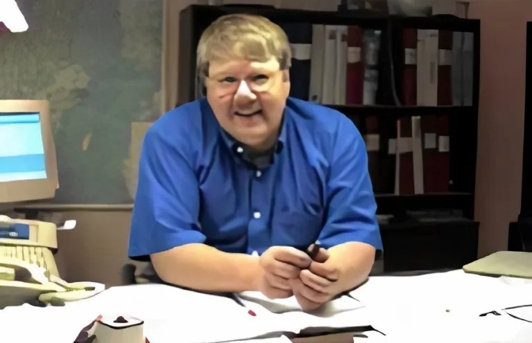 Man in a blue shirt at a desk