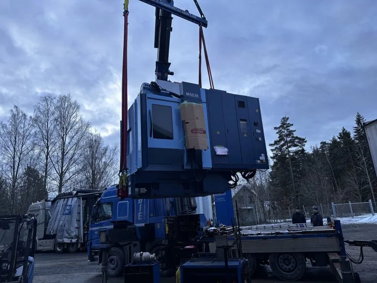 Bearbetningscenter som lyfts med kran från en lastbil